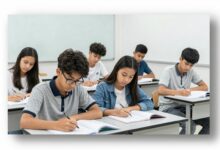 Estudantes focados em uma sala de aula moderna, revisando materiais para o vestibular