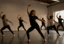 Grupo diversificado de pessoas praticando dança contemporânea em um estúdio iluminado, cada um expressando movimentos únicos e criativos
