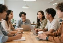 Um grupo diversificado de colegas de trabalho sorrindo e conversando animadamente durante uma pausa para o café em um escritório moderno e iluminado.