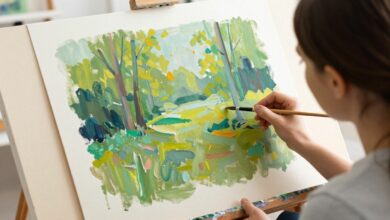 Pessoa iniciando um curso de pintura em tela, aprendendo técnicas com pincéis e tintas coloridas em ambiente acolhedor